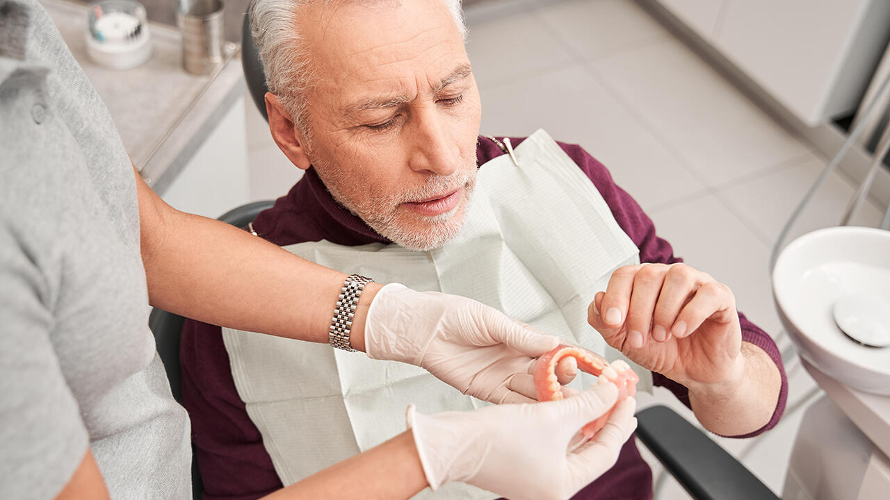 Prothesen sollten regelmäßig beim Zahnarzt auf ihre Passform untersucht werden. Sonst können sich Druckstellen im Mund bilden.