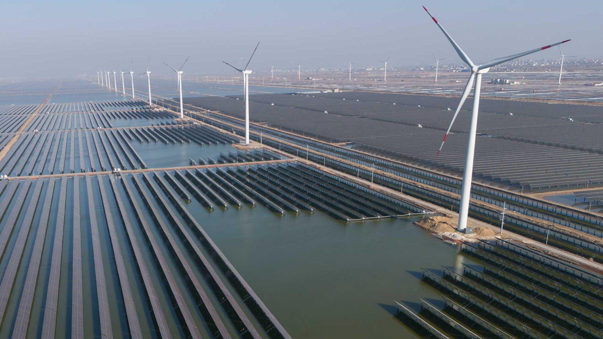 22.03.2024, China, Weifang: Windturbinen säumen die Küstenlinie entlang eines riesigen Solarparks.