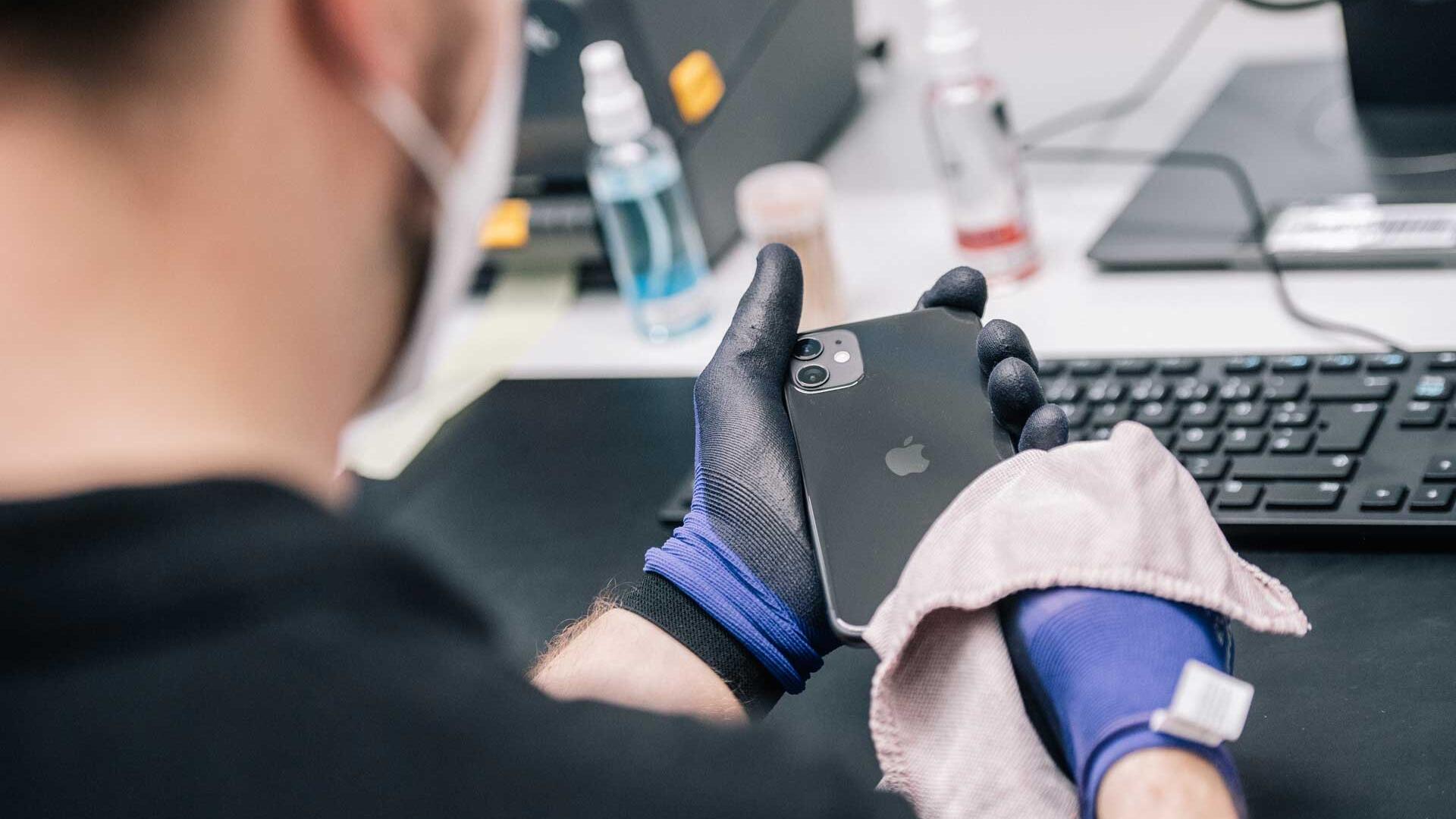 Ein Mitarbeiter überprüft ein refurbished Iphone