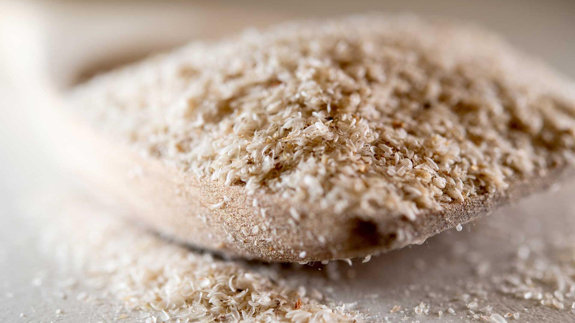 Flohsamenschalen auf einem Holzlöffel