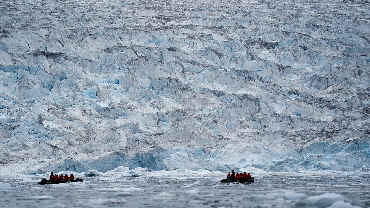 Grönland, Scoresby Sund: Zwei Gruppen von Poseidon Expeditions betrachten einen Gletscher, der auf der Wasserlinie im Scoresby Sund liegt.