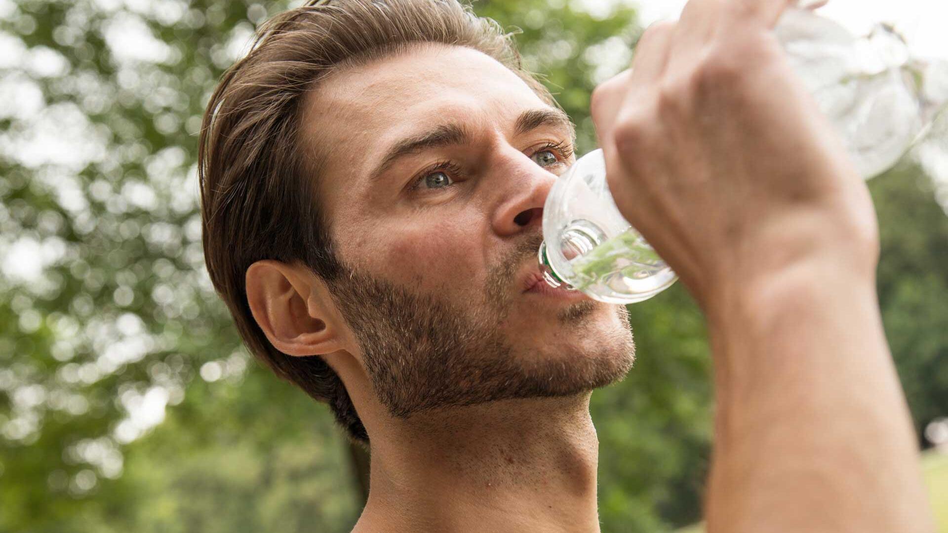 Mann trinkt Wasser aus einer PET-Flasche
