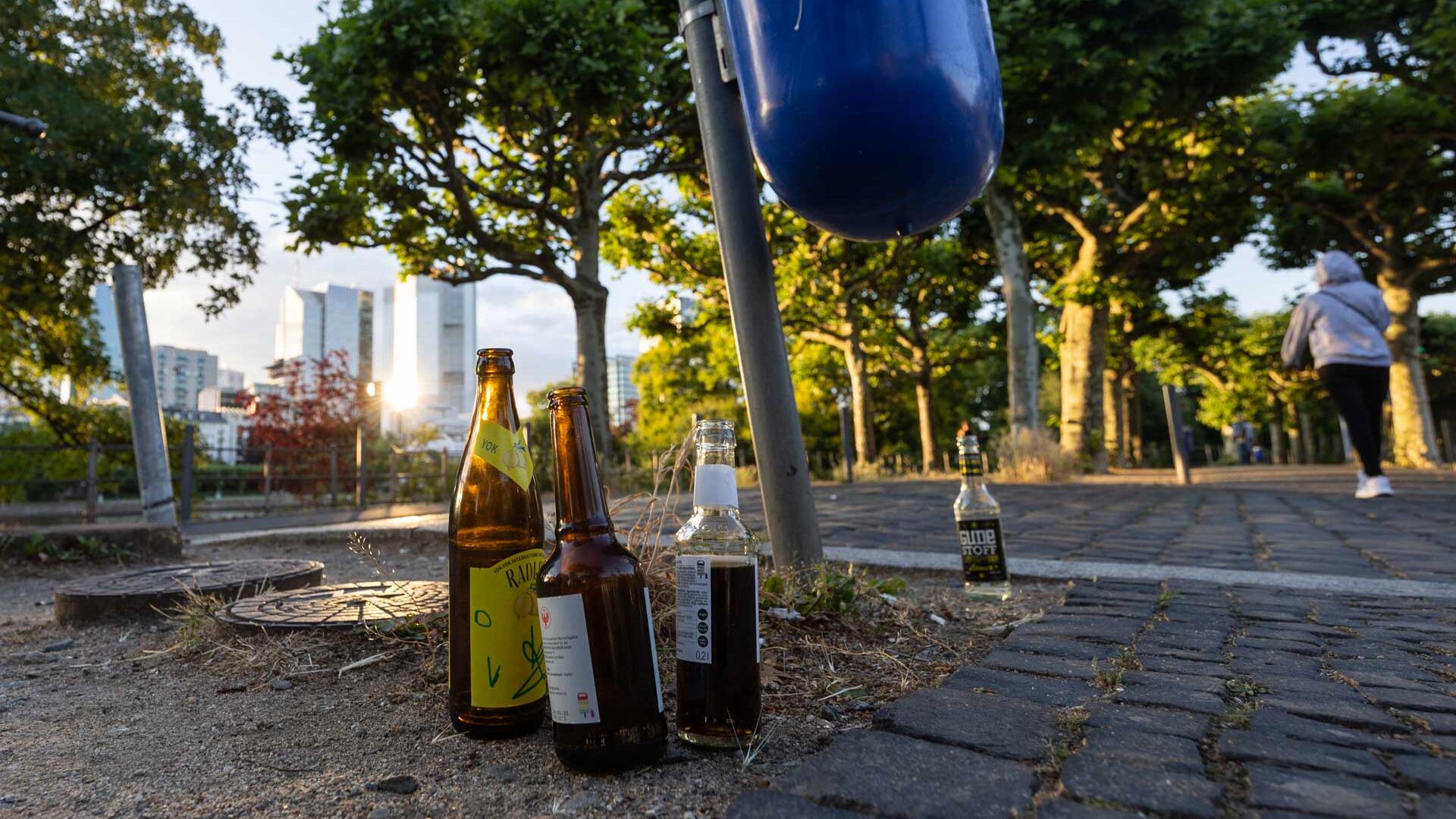 Nahe dem Frankfurter Mainufer sind Glasflaschen abgestellt.