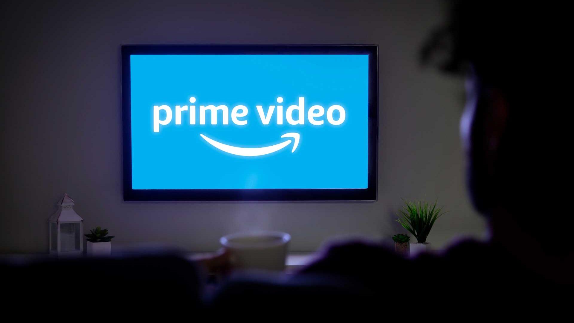 Person sitzt vor Fernseher, dieser zeigt das Amazon-Prime-Logo.