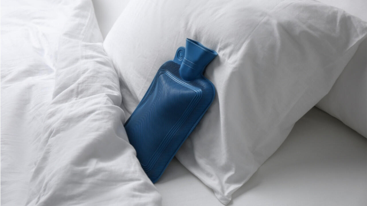 Ein Wärmflasche lädt zum Kuscheln im Bett ein, doch Sie sollten sie dort nicht länger gefüllt liegen lassen.