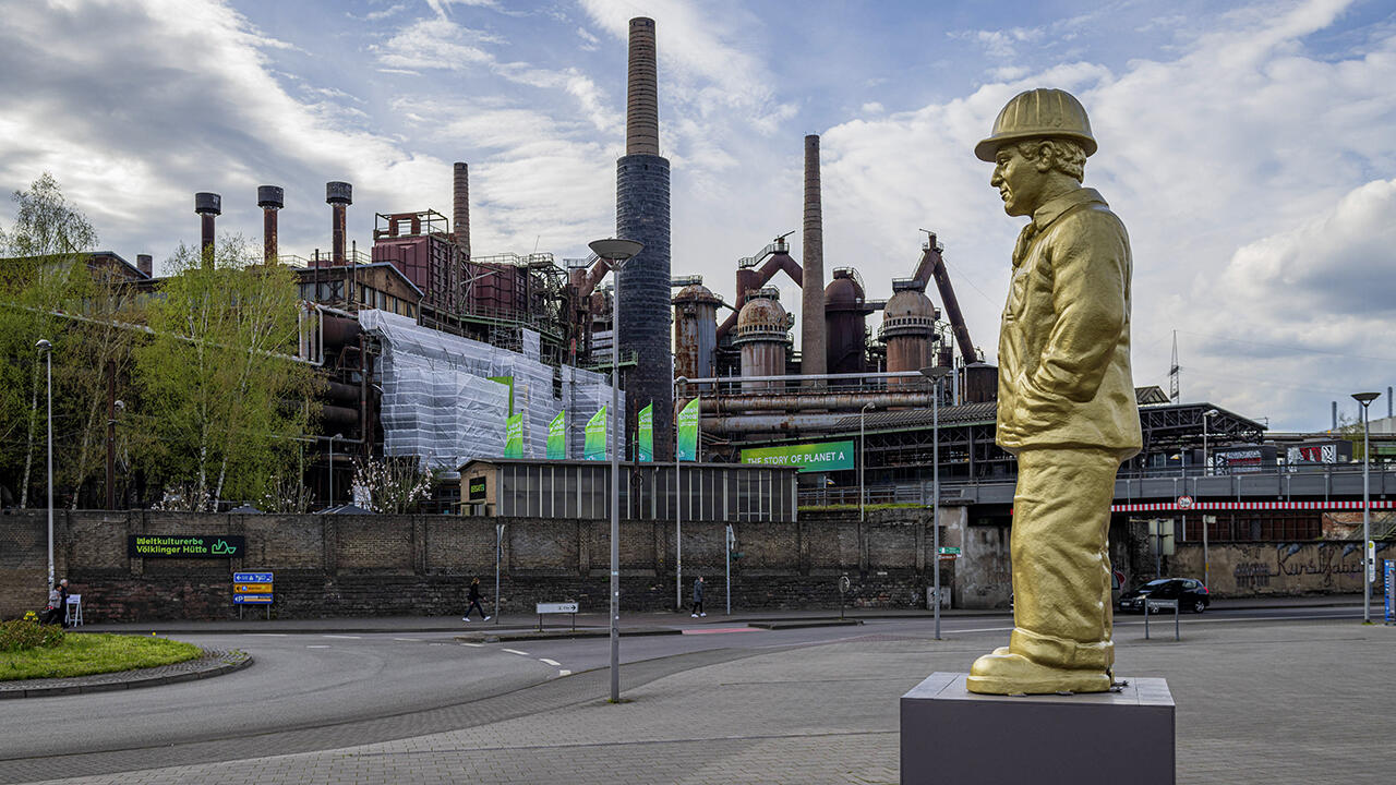 Die 6,20 Meter hohe Skulptur eines Hüttenarbeiters steht vor dem Weltkulturerbe Völklinger Hütte