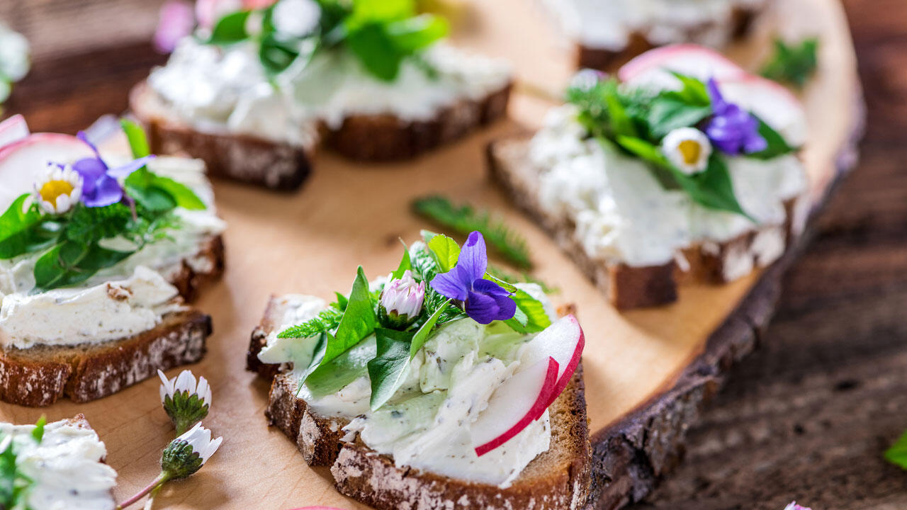 Sie können essbare Wildkräuter beispielsweise nutzen, um damit Frischkäse-Schnittchen aufzuhübschen.