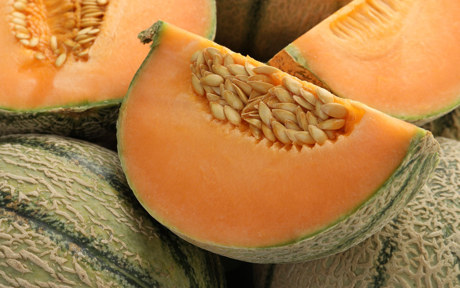 Die Cantaloupe-Melone ist an ihrer netzartig strukturierten Schale und dem leuchtend orangefarbenen, besonders aromatischen Fruchtfleisch zu erkennen.