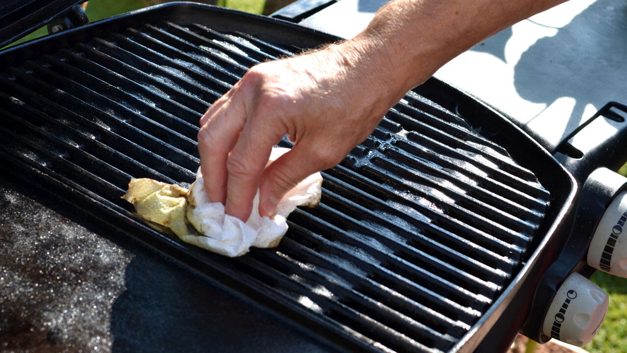 Grill reinigen: Mit einem Tuch werden direkt nach dem Grillen die gröbsten Verschmutzungen entfernt. Grill reinigen: Mit einem Tuch werden direkt nach dem Grillen die gröbsten Verschmutzungen entfernt.