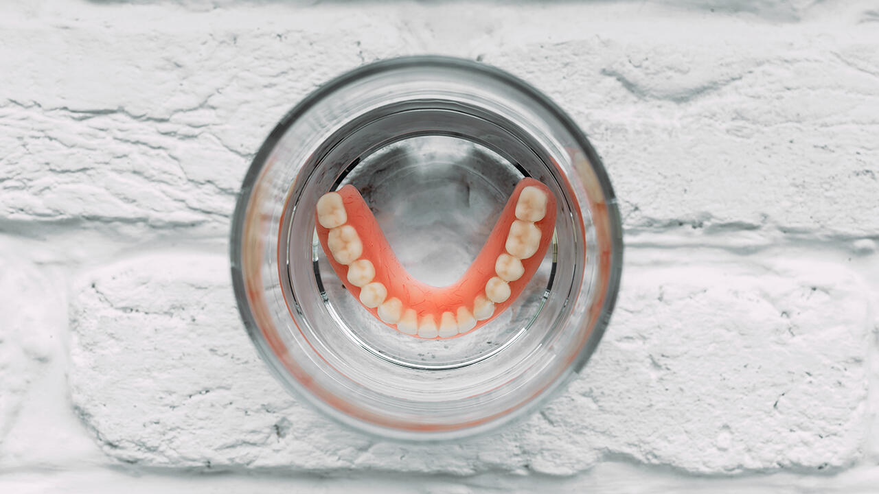 Künstliche Zähne sollten täglich mit Gebissreiniger gereinigt werden.