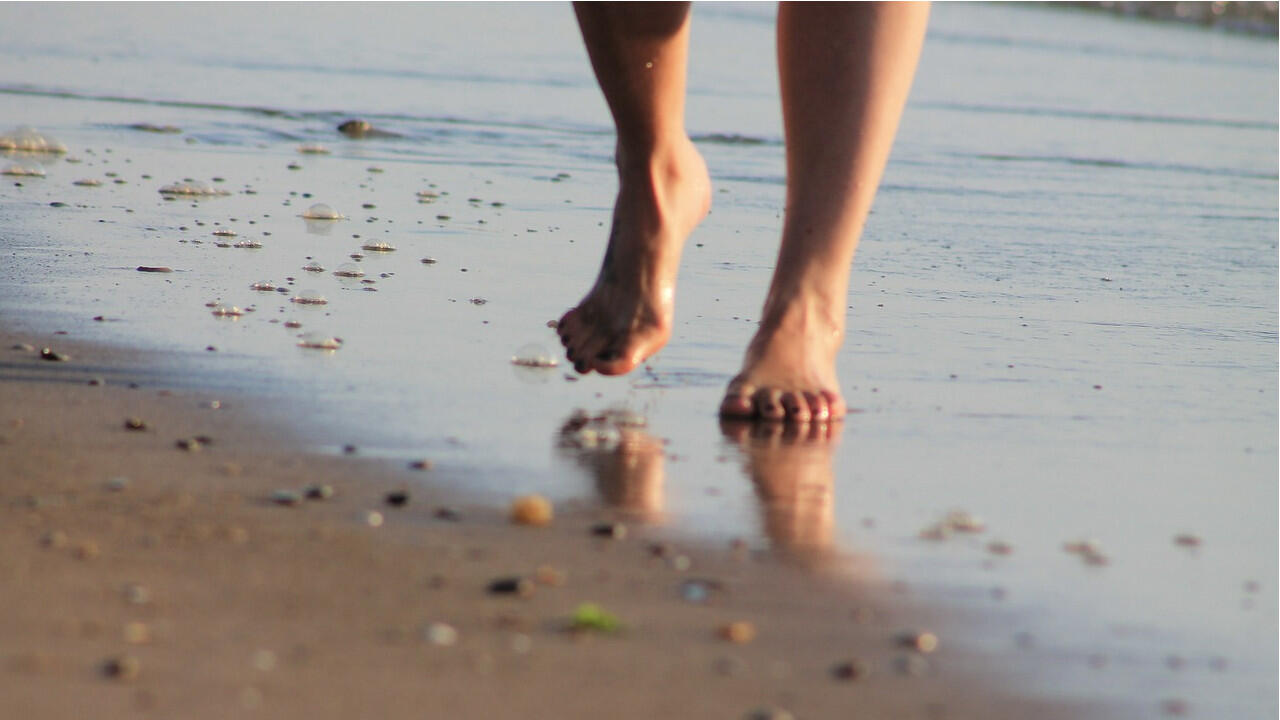 Gewöhnen Sie Ihre Füße auf weichem Untergrund wie Sand ans Barfußlaufen.