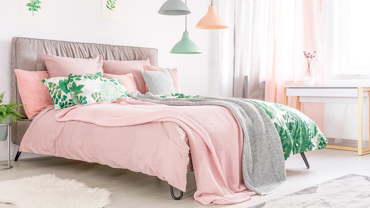 Es muss nicht immer eintönig sein: Kontraste aus verschiedenen Stoffen, Mustern und Farben peppen das Schlafzimmer auf.