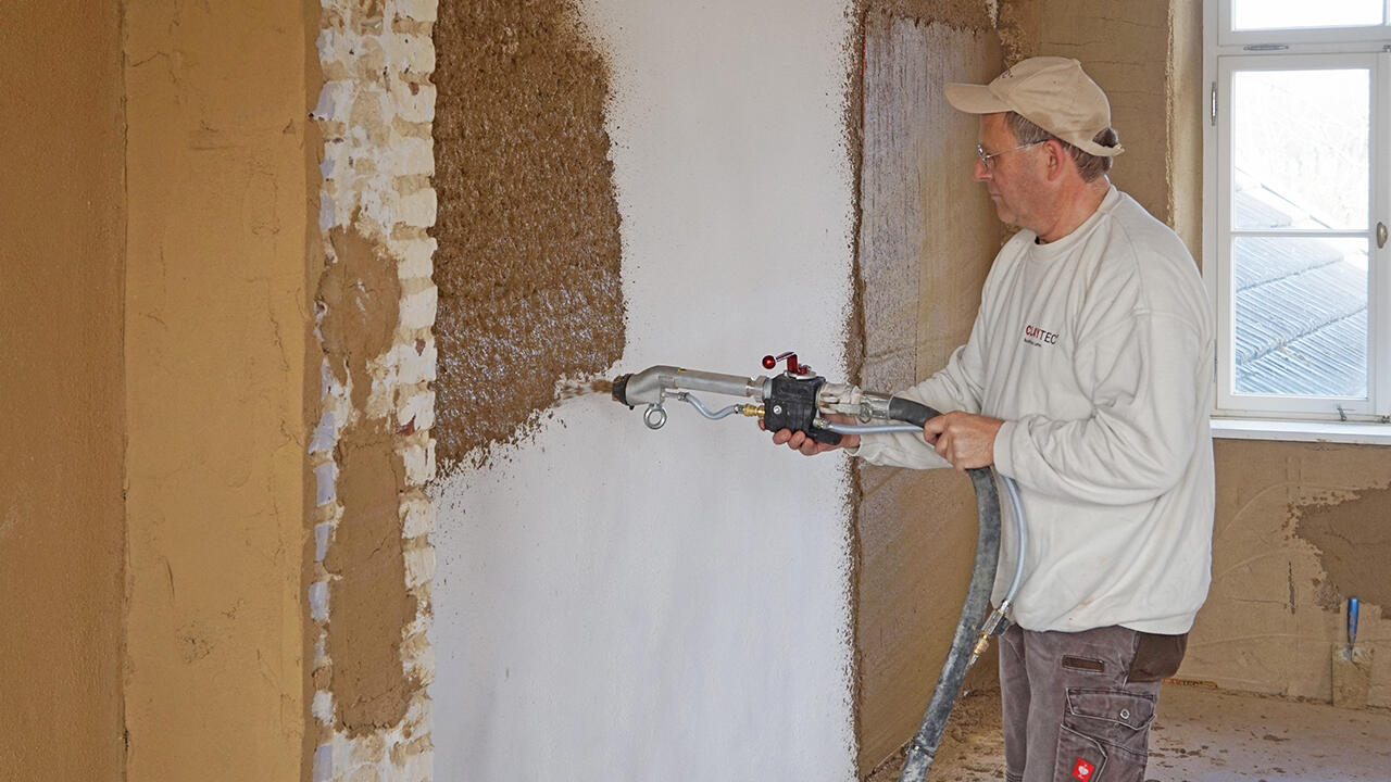 Wände mit Lehm verputzen: Auf größere Flächen ist eine Putzmaschine hilfreich.